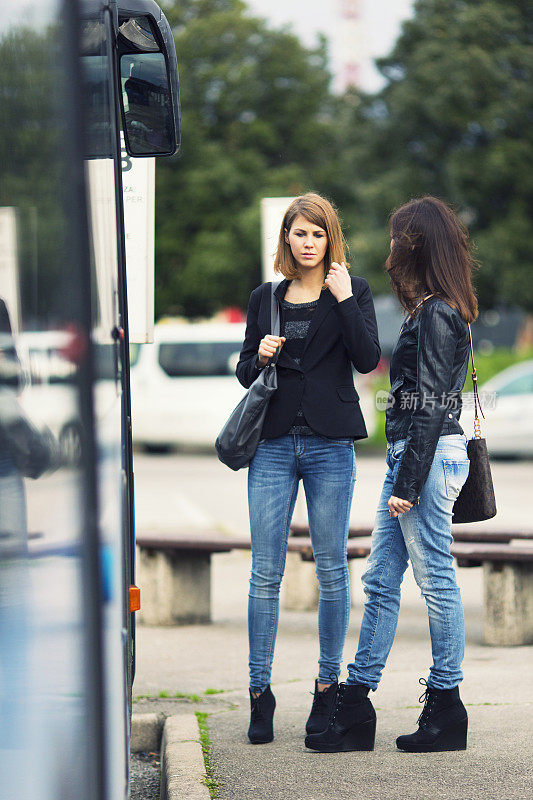 Young women waiting on the bus station